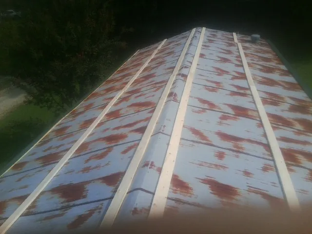 Rusted metal roof panels with new wood purlins before replacement — Storm Damage Roof Repair in Spicewood by Roofing Brothers