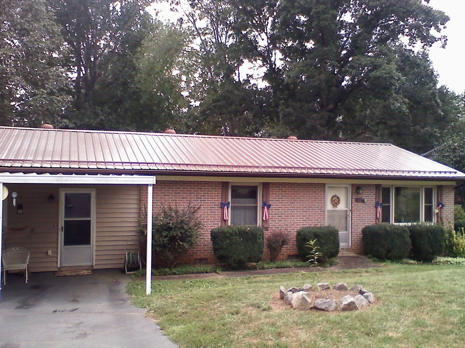Bronze metal roof and carport on a brick ranch home — Roof Repair work by our crew in Spicewood